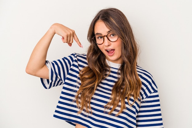 Jonge blanke vrouw geïsoleerd op een witte achtergrond persoon die met de hand wijst naar een shirt kopieerruimte, trots en zelfverzekerd?