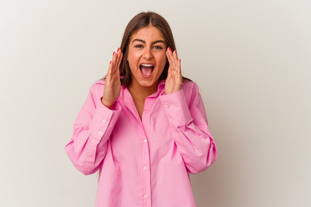 Jonge blanke vrouw geïsoleerd op een witte achtergrond schreeuwen opgewonden naar voren.