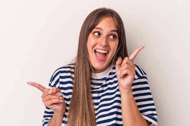 Jonge blanke vrouw geïsoleerd op een witte achtergrond, wijzend naar verschillende kopieerruimten, een van hen kiezend, tonend met de vinger.