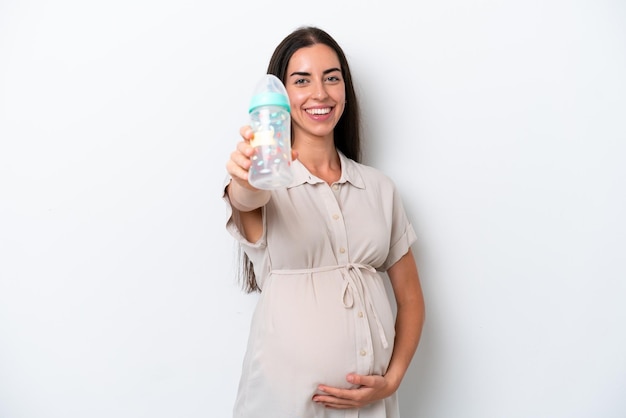 Jonge blanke vrouw geïsoleerd op een witte achtergrond zwanger en met een zuigfles