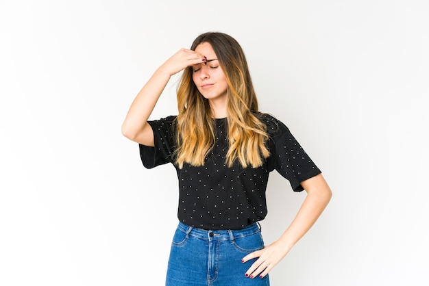 Jonge blanke vrouw geïsoleerd op een witte ruimte met een hoofdpijn, de voorkant van het gezicht aan te raken.