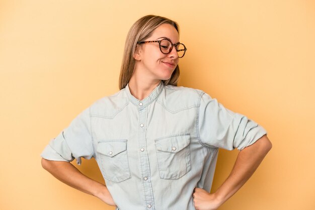 Jonge blanke vrouw geïsoleerd op gele achtergrond dromen van het bereiken van doelen en doeleinden