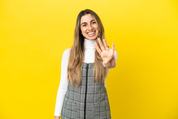 Jonge blanke vrouw geïsoleerd op gele achtergrond gelukkig en vier tellen met vingers
