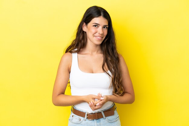 Jonge blanke vrouw geïsoleerd op gele achtergrond lachen