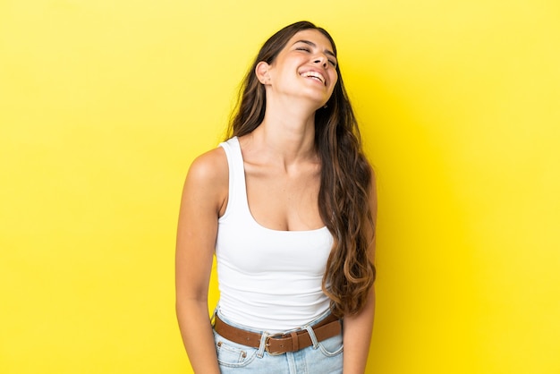 Jonge blanke vrouw geïsoleerd op gele achtergrond lachen