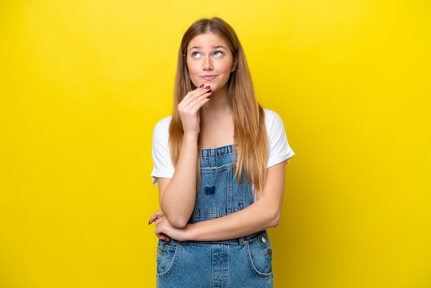 Jonge blanke vrouw geïsoleerd op gele achtergrond te kijken tijdens het glimlachen