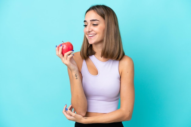 Jonge blanke vrouw geïsoleerd op paarse achtergrond met een appel en happy