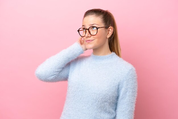 Jonge blanke vrouw geïsoleerd op roze achtergrond denken een idee