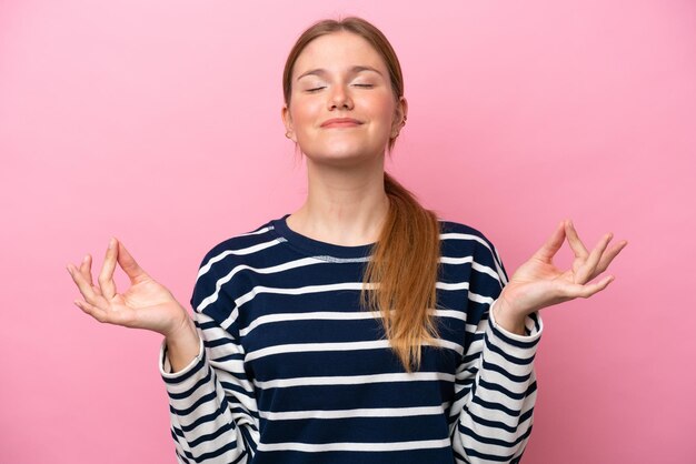 Jonge blanke vrouw geïsoleerd op roze achtergrond in zen pose