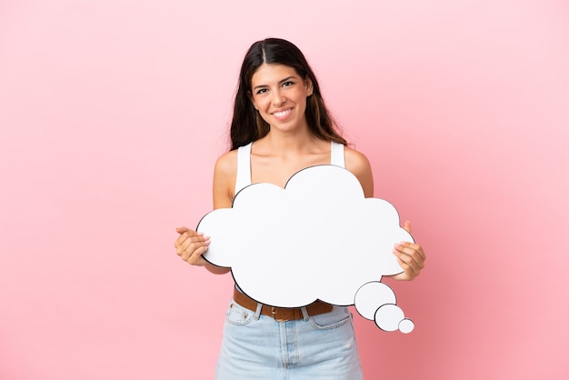 Jonge blanke vrouw geïsoleerd op roze achtergrond met een denkende tekstballon