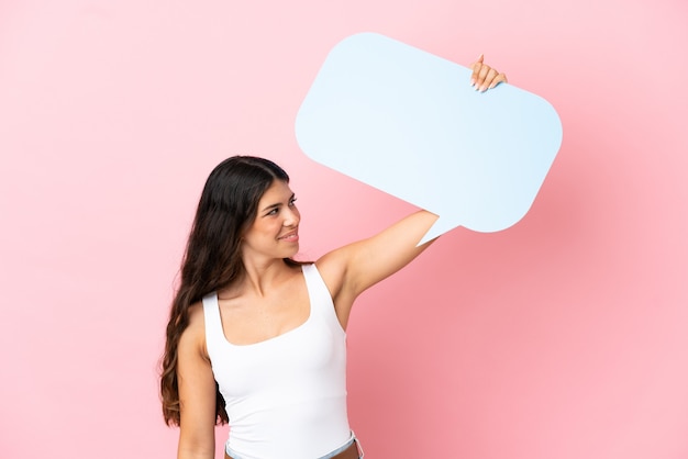 Jonge blanke vrouw geïsoleerd op roze achtergrond met een lege tekstballon