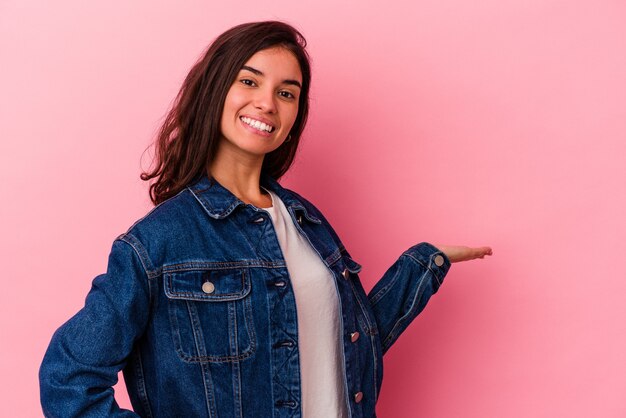 Jonge blanke vrouw geïsoleerd op roze achtergrond met een welkome uitdrukking.