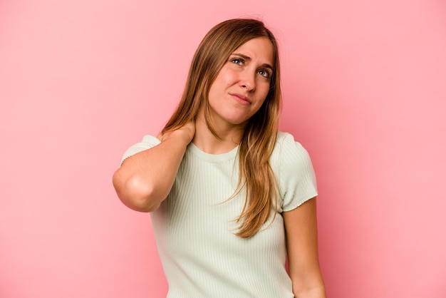 Jonge blanke vrouw geïsoleerd op roze achtergrond met nekpijn als gevolg van stress, masseren en aanraken met de hand