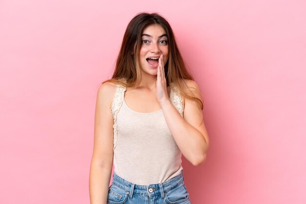 Jonge blanke vrouw geïsoleerd op roze achtergrond met verrassing en geschokte gezichtsuitdrukking