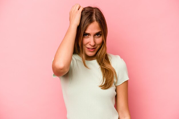 Jonge blanke vrouw geïsoleerd op roze achtergrond moe en erg slaperig hand op het hoofd houden