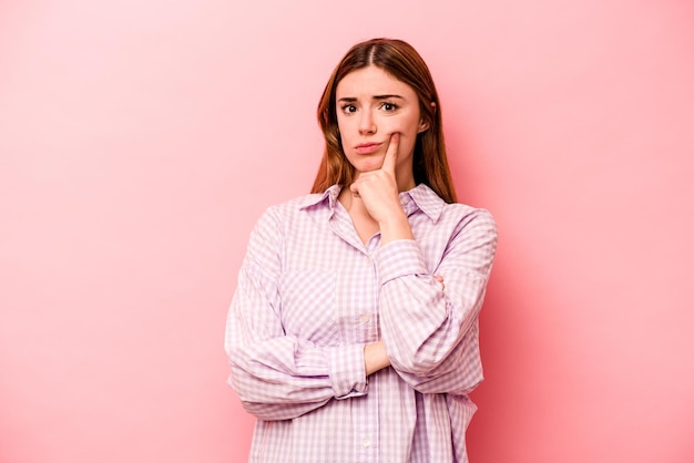 Jonge blanke vrouw geïsoleerd op roze achtergrond ongelukkig kijken in de camera met sarcastische uitdrukking