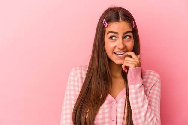 Jonge blanke vrouw geïsoleerd op roze achtergrond ontspannen denken over iets kijken naar een kopie ruimte.