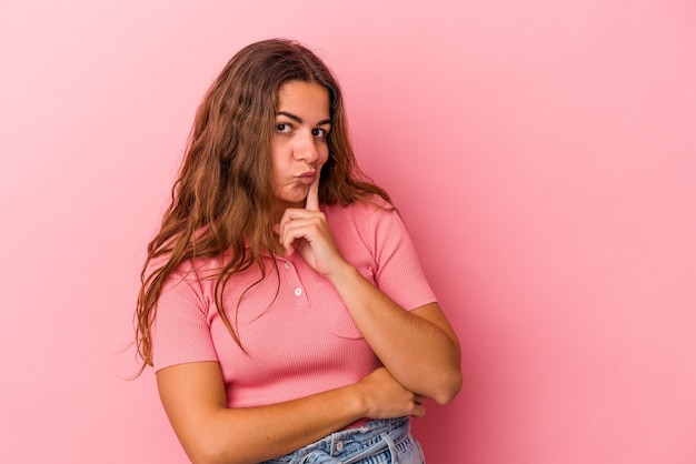 Jonge blanke vrouw geïsoleerd op roze achtergrond overweegt, een strategie plannen, nadenken over de manier van een bedrijf.