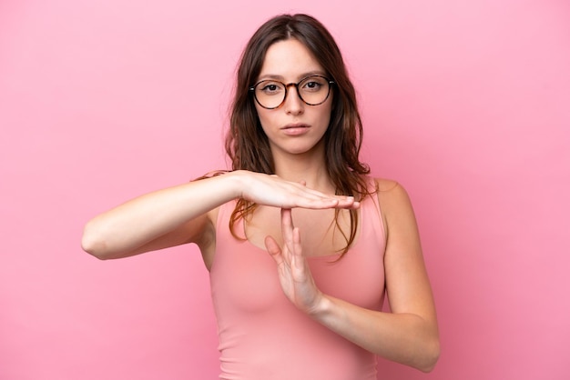 Foto jonge blanke vrouw geïsoleerd op roze achtergrond time-out gebaar maken