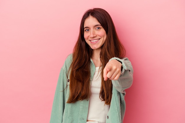 Jonge blanke vrouw geïsoleerd op roze achtergrond vrolijke glimlach wijzend naar voren.