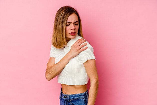 Jonge blanke vrouw geïsoleerd op roze met pijn in de schouder.