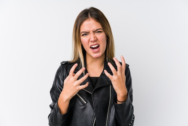 Jonge blanke vrouw, gekleed in een zwart lederen jas boos schreeuwen met gespannen handen.