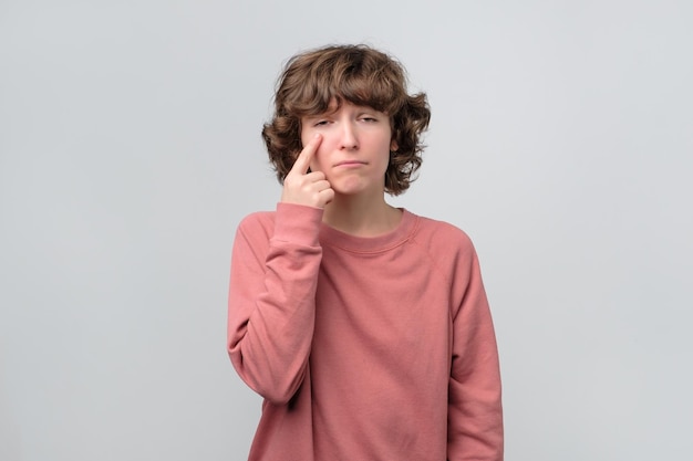 Jonge blanke vrouw in roze trui staat op het punt te huilen