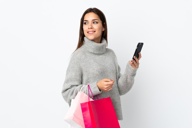 Jonge blanke vrouw met boodschappentassen en een mobiele telefoon