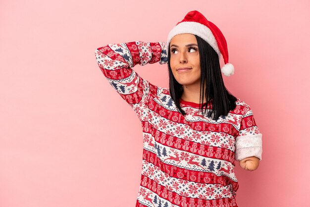Jonge blanke vrouw met één arm die Kerstmis viert geïsoleerd op een roze achtergrond die de achterkant van het hoofd aanraakt, denkt en een keuze maakt.