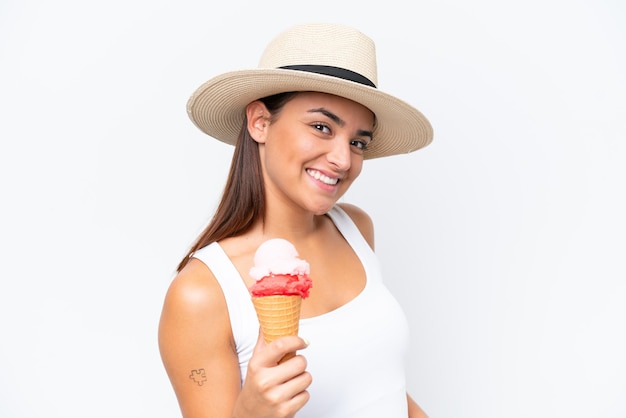 Jonge blanke vrouw met een cornet-ijs geïsoleerd op een witte achtergrond lacht veel