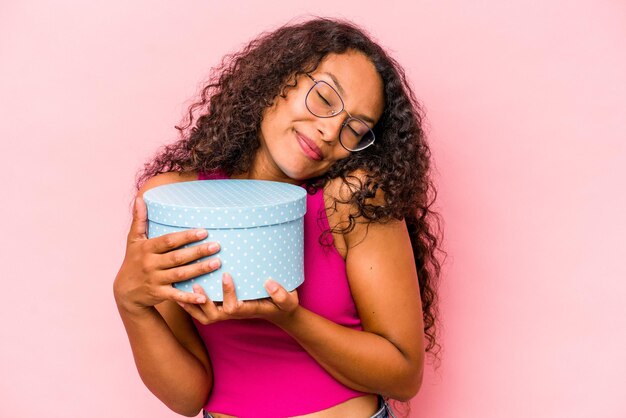 Jonge blanke vrouw met een geschenkdoos geïsoleerd op roze background