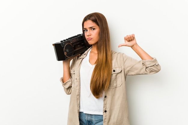 Jonge blanke vrouw met een guettoblaster voelt zich trots en zelfverzekerd, voorbeeld om te volgen.