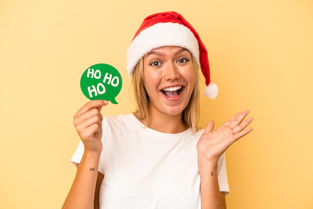 Jonge blanke vrouw met een kerst rekwisieten geïsoleerd op gele achtergrond