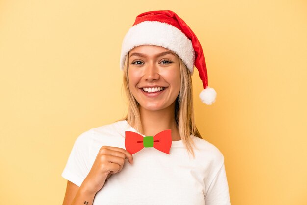 Jonge blanke vrouw met een kerst rekwisieten geïsoleerd op gele achtergrond