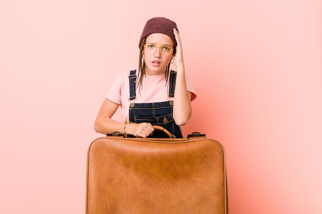 Jonge blanke vrouw met een koffer die geschokt is, heeft ze een belangrijke vergadering onthouden.