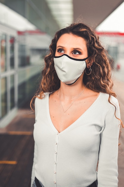 Jonge blanke vrouw met een masker in een stedelijk gebied