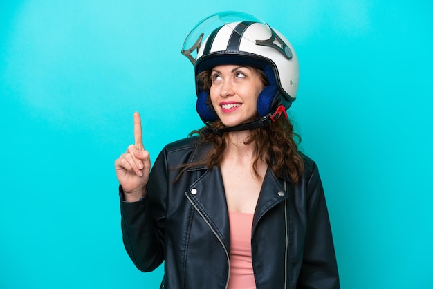 Jonge blanke vrouw met een motorhelm geïsoleerd op een blauwe achtergrond die een geweldig idee benadrukt