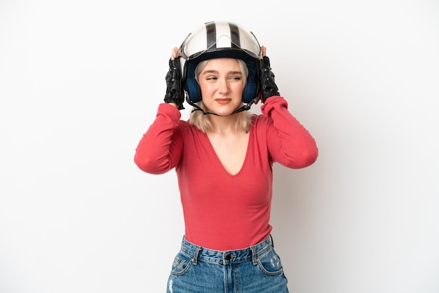 Jonge blanke vrouw met een motorhelm geïsoleerd op een witte achtergrond gefrustreerd en die oren bedekt