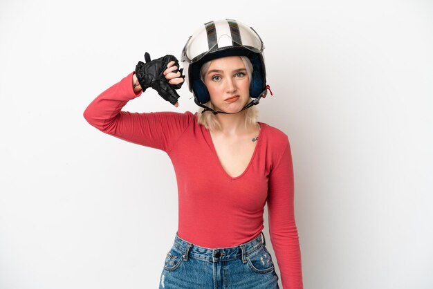 Jonge blanke vrouw met een motorhelm geïsoleerd op een witte achtergrond met duim omlaag met negatieve uitdrukking