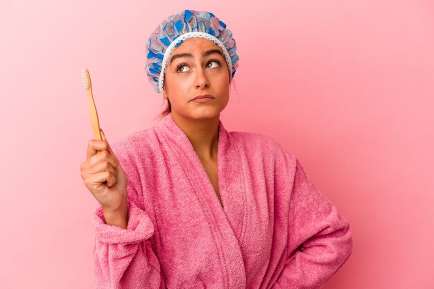 Jonge blanke vrouw met een tandenborstel geïsoleerd op roze background