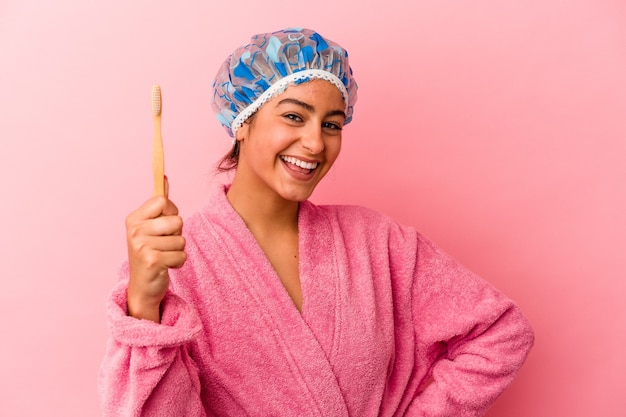 Jonge blanke vrouw met een tandenborstel geïsoleerd op roze background