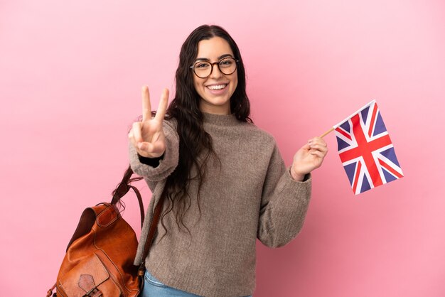 Jonge blanke vrouw met een vlag van het Verenigd Koninkrijk geïsoleerd