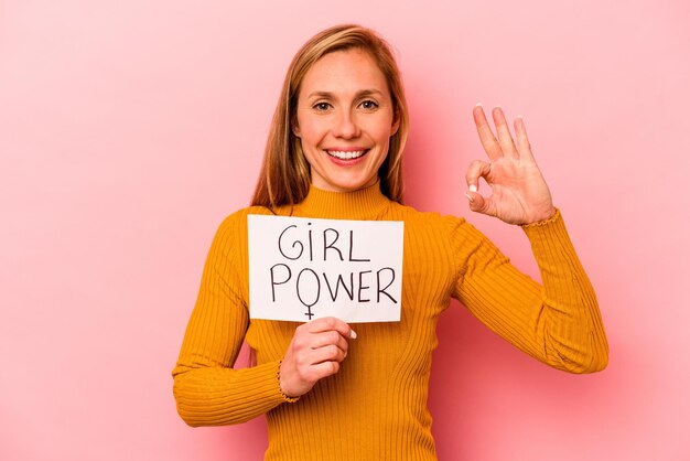 Jonge blanke vrouw met girl power plakkaat geïsoleerd op roze achtergrond