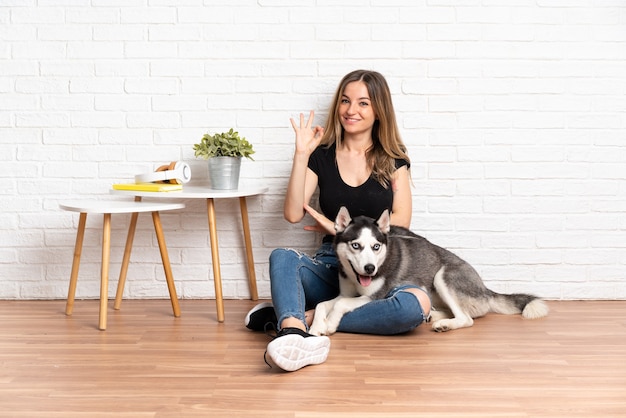 Jonge blanke vrouw met haar hond binnenshuis