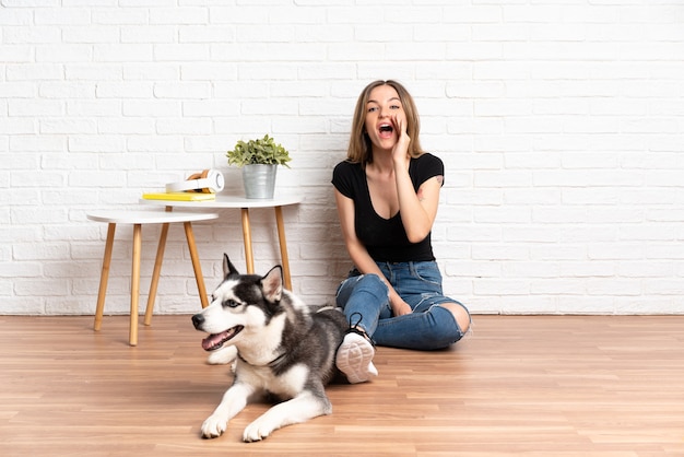 Jonge blanke vrouw met haar hond binnenshuis