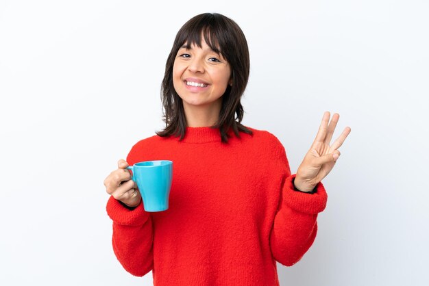 Jonge blanke vrouw met kopje koffie geïsoleerd op een witte achtergrond gelukkig en drie tellen met vingers