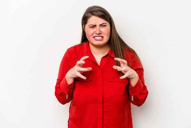 Jonge blanke vrouw met overgewicht geïsoleerd op een witte achtergrond boos schreeuwen met gespannen handen.