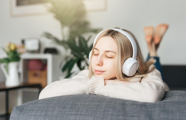 Jonge blanke vrouw ontspant thuis met muziek