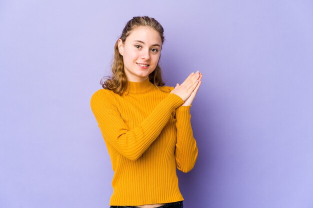 Jonge blanke vrouw op paars gevoel energiek en comfortabel, handen zelfverzekerd wrijven.