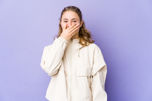 Jonge blanke vrouw op paarse achtergrond lachen gelukkige, zorgeloze, natuurlijke emotie.